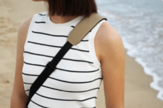 Padded shoulder belt on a striped top with beach in the background
